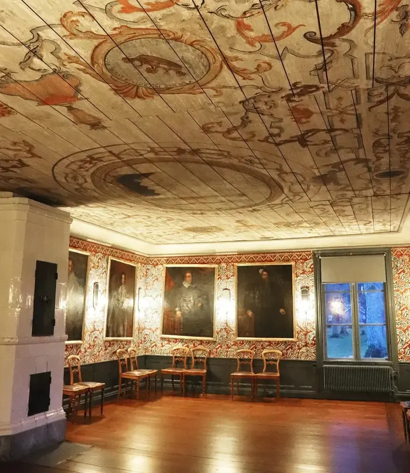Ett 1700-talsrum med målat tak med ornament runt en mittmedaljong.