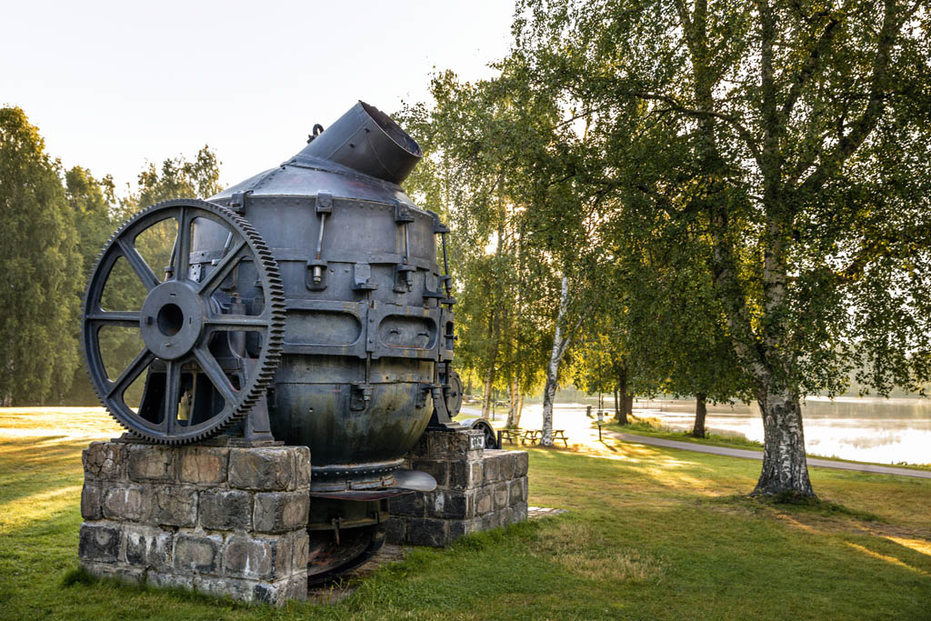 En stort svart metallbehållare står uppställd i en park