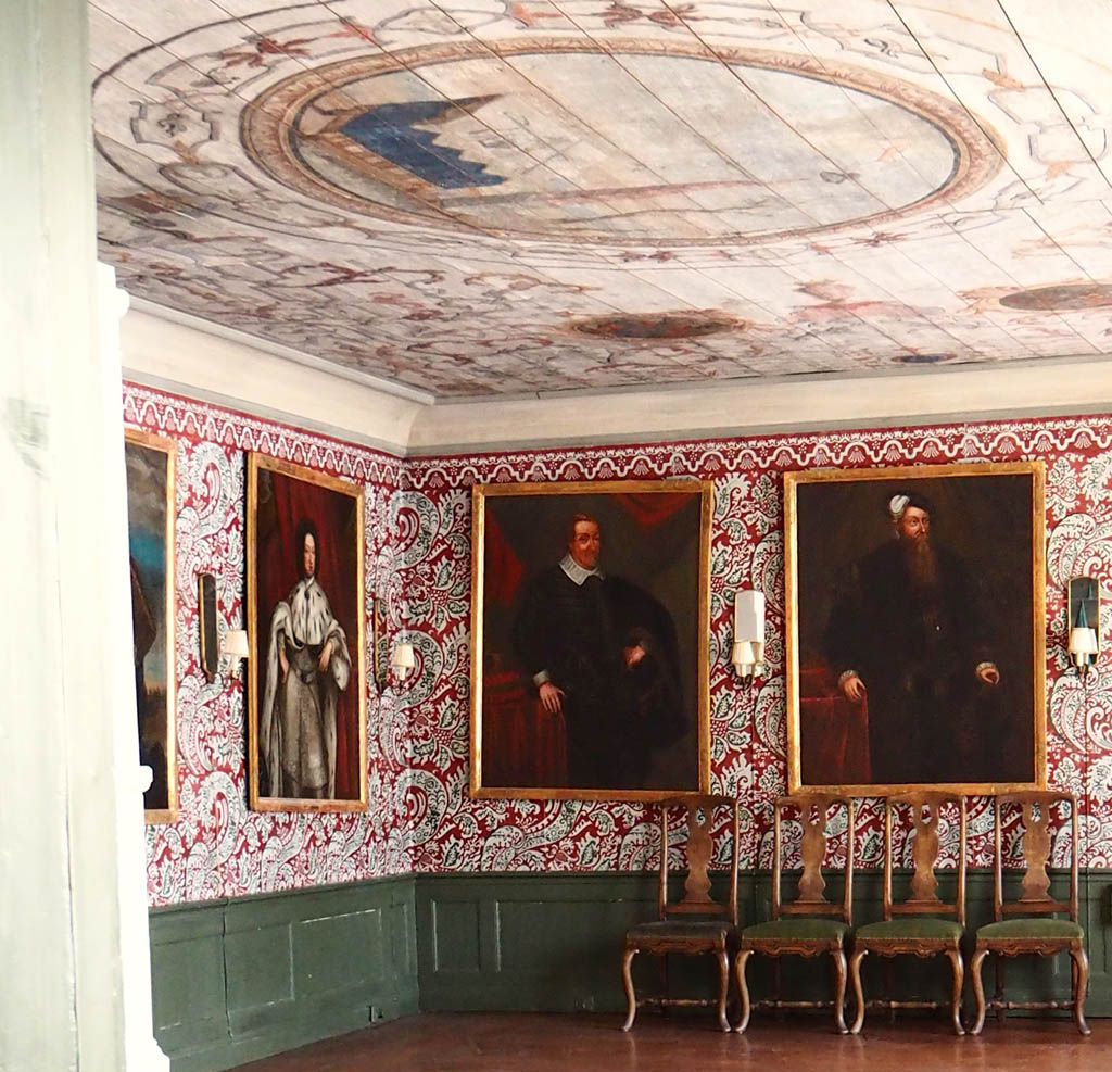 1700-talsinteriör med kungaporträtt på väggarna och målat tak