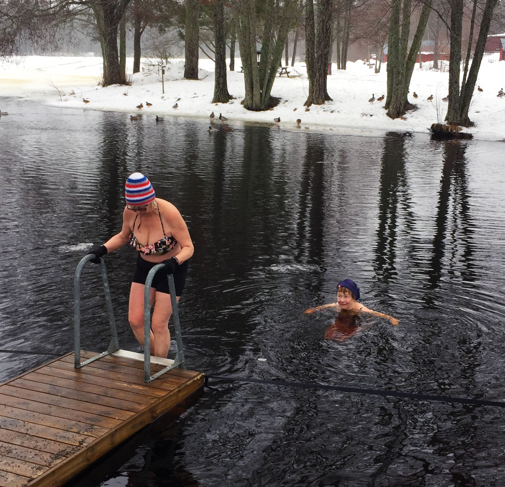 Två kvinnor badar i ett vinterlandskap