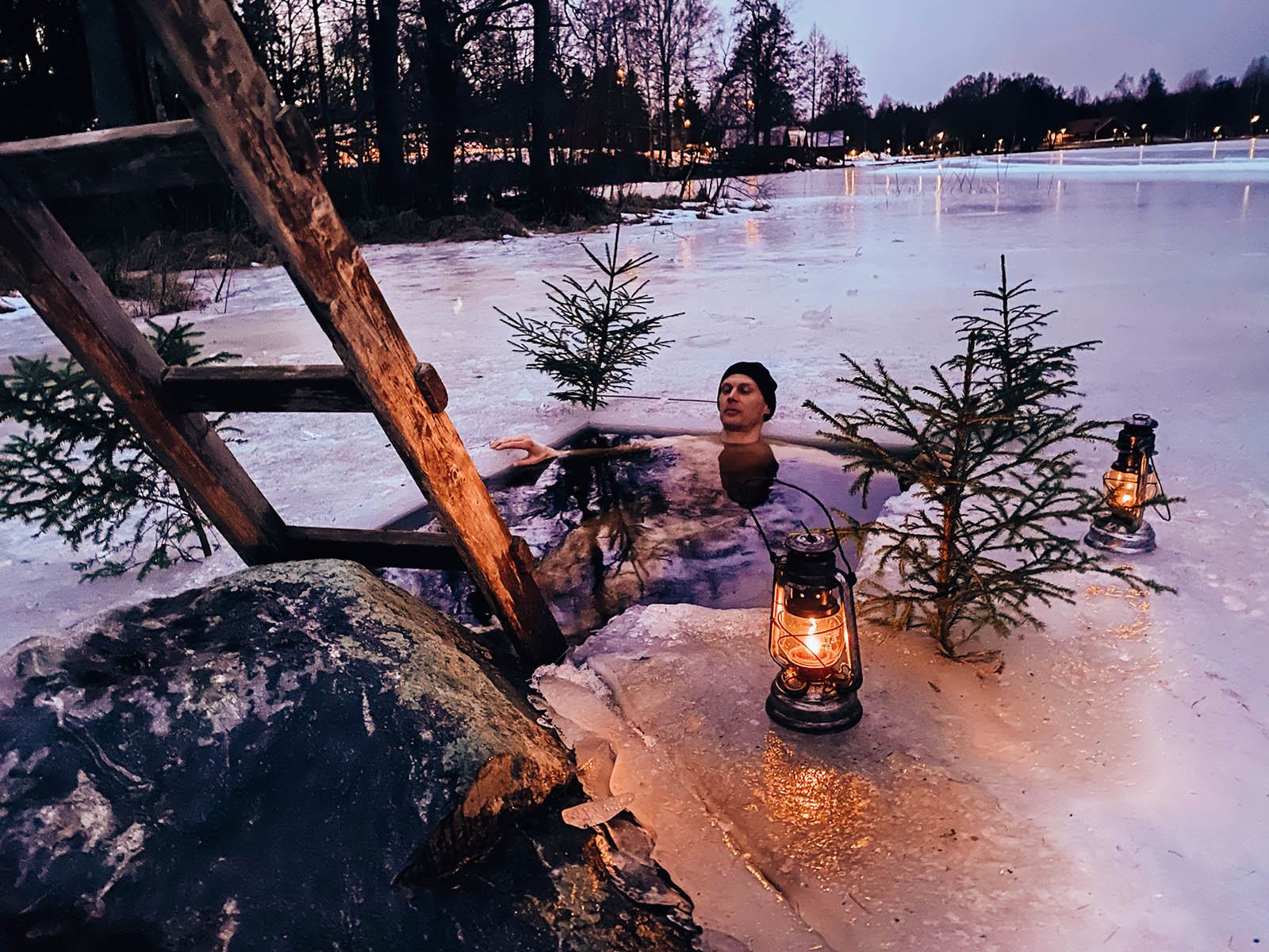 En man badar i en isvak en stämningsfull kväll. 