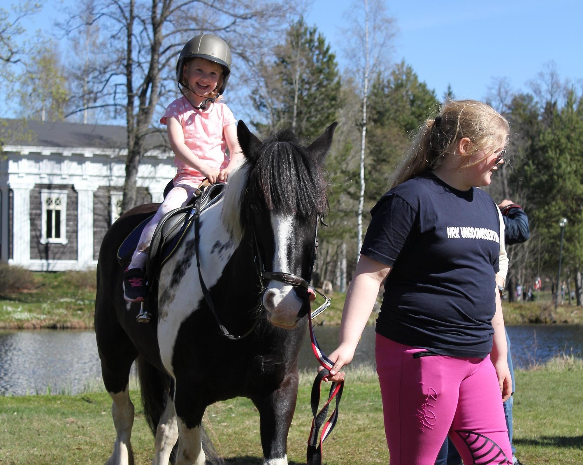 Ett barn som glatt rider på en ponny.