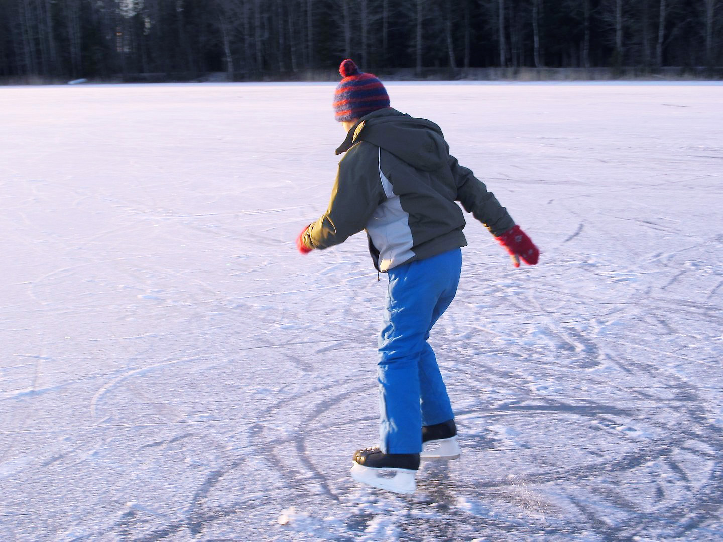 Ett barn åker skridskor på en istäckt sjö.