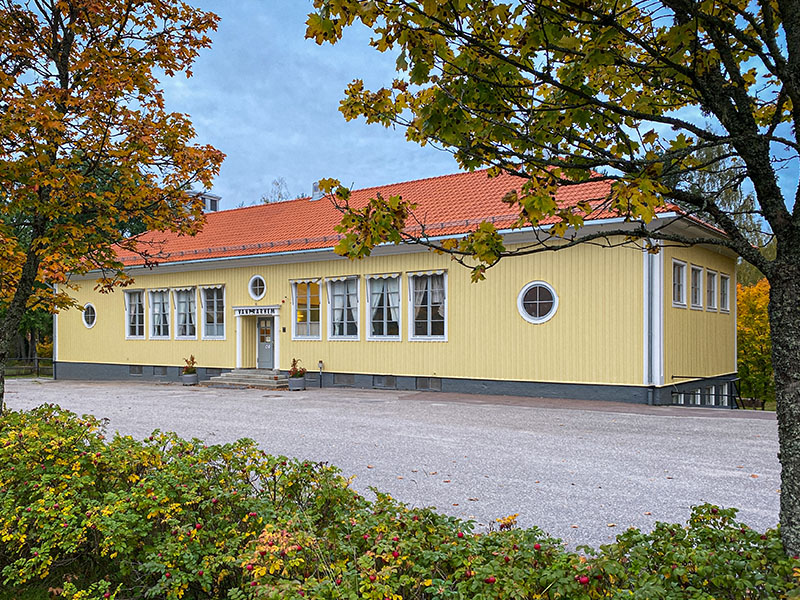 Vandrarhemmet, en enplans gul byggnad, i höstskrud
