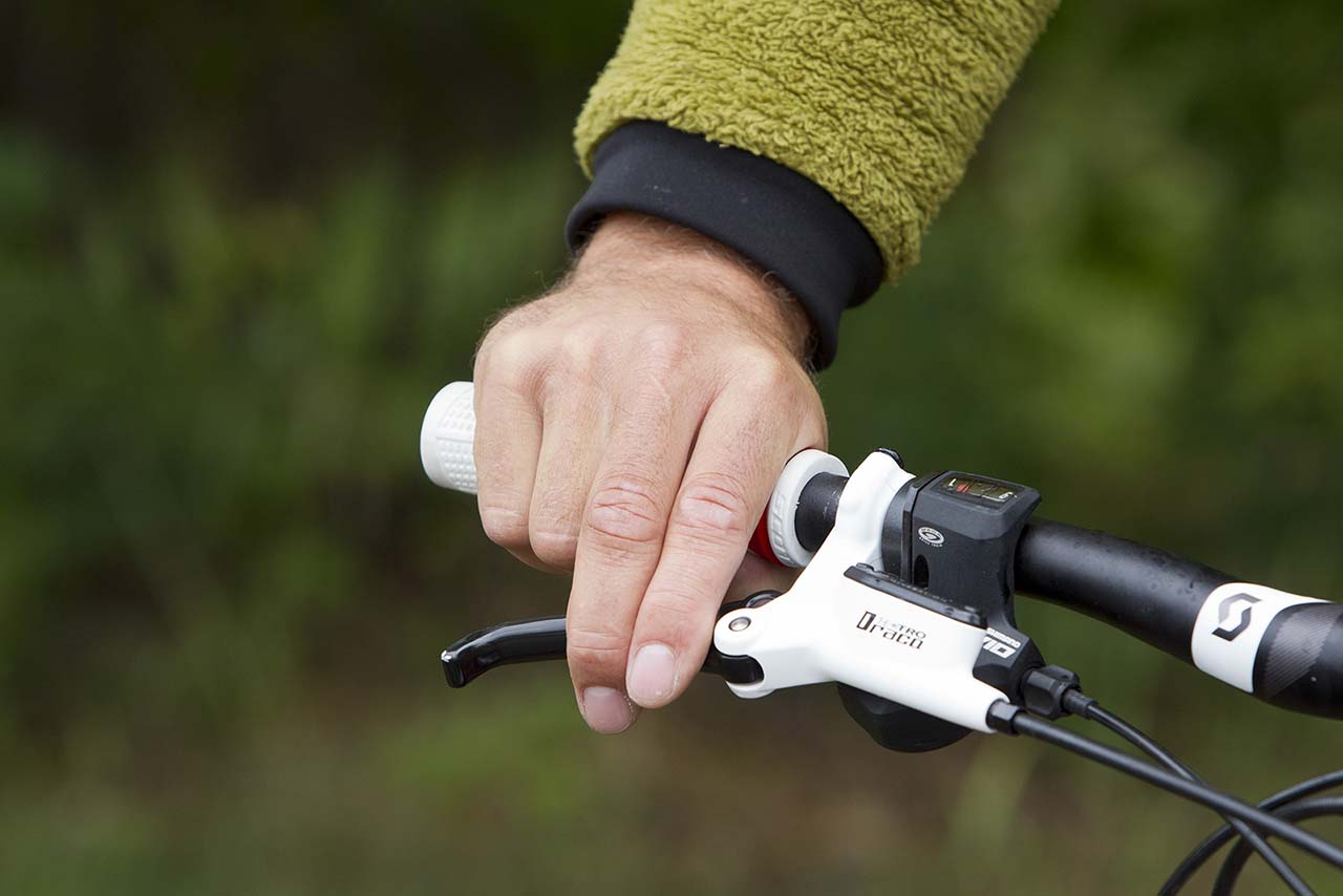 Närbild av en hand som håller ett cykelhandtag med handbroms. 