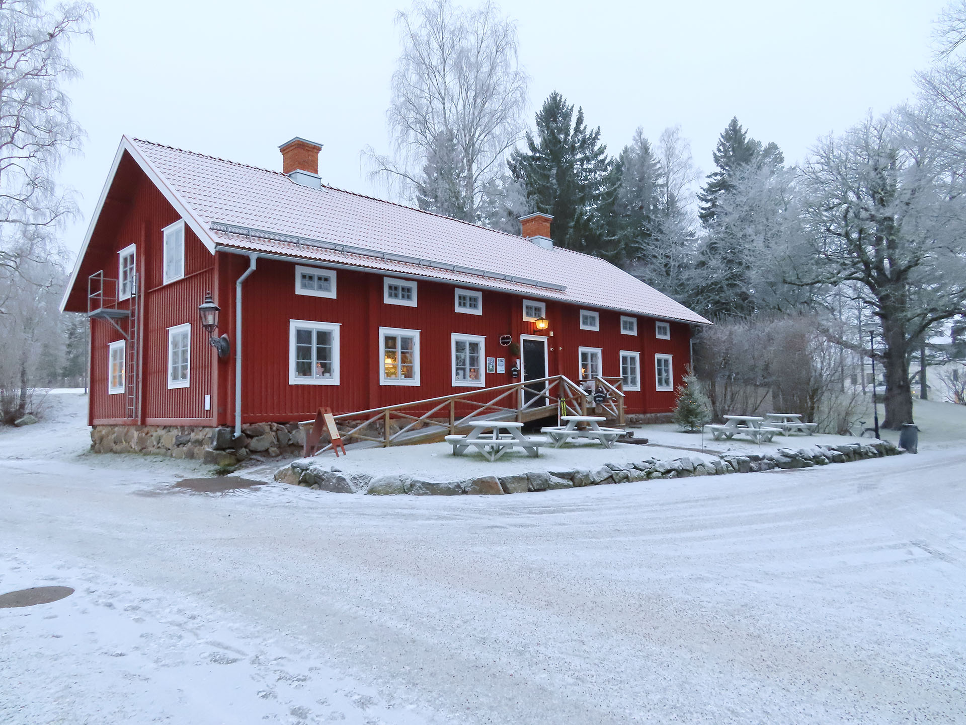 En röd timmerbyggnad i snö.