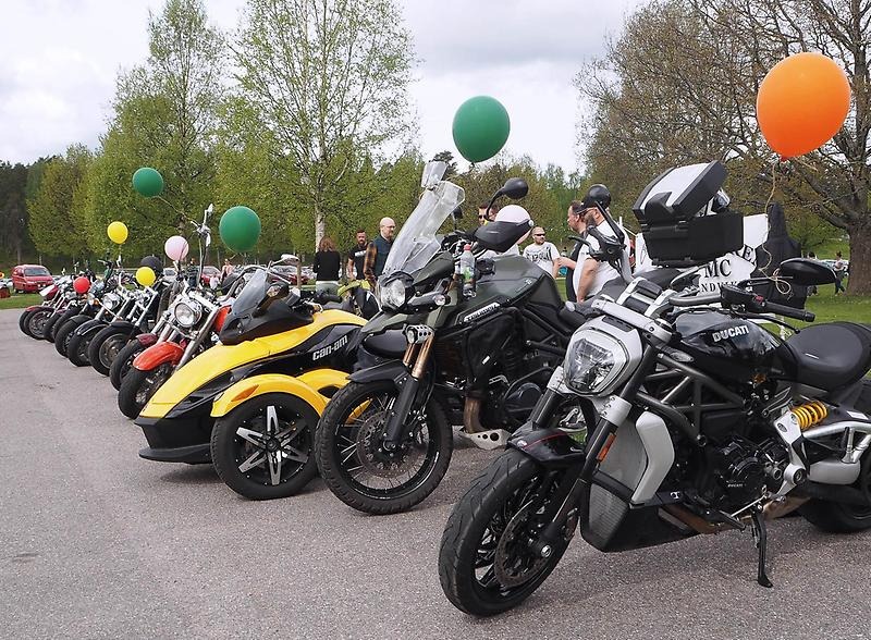 Motorcyklar står på rad med ballonger fastknutna. 